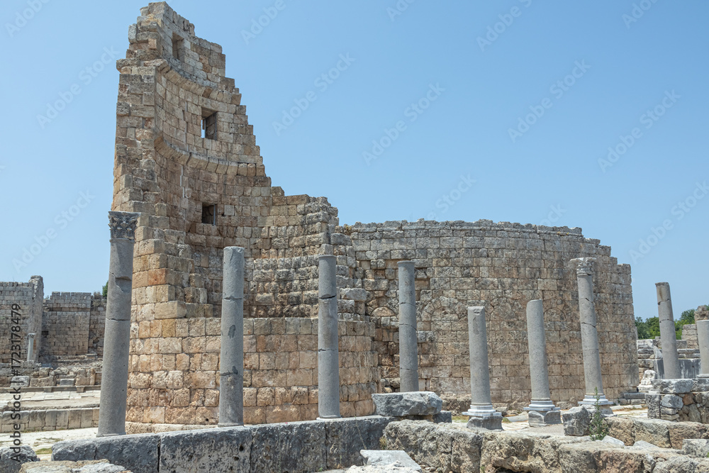Fototapeta premium Columns and ruins of buildings in the ancient city of Perge in Turkey. An ancient city founded during the Trojan War. Smooth and elaborately crafted columns on the streets of the ancient city.