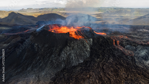 Epic panoramic aerial view of a vast volcanic valley with an erupting crater in Iceland.