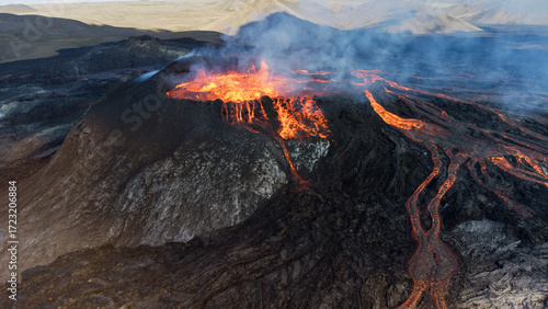 Intense aerial shot of a crater with churning magma and volcanic smoke.