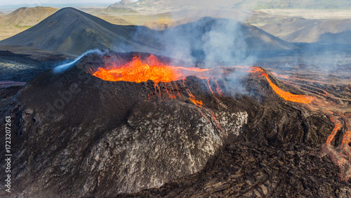 Aerial view of an active volcano crater venting steam and gas during an eruption in Iceland.