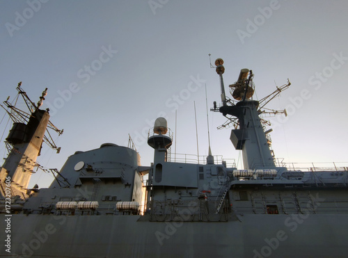 Radars on top of a large modern warship against a clear sunny sky