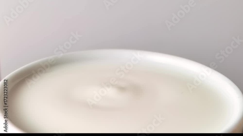 Milk drop falling and splashing in a bowl with milk