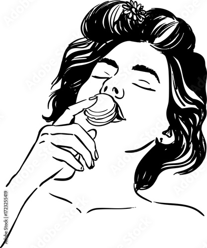 A woman with a flower in her hair eats a macaron