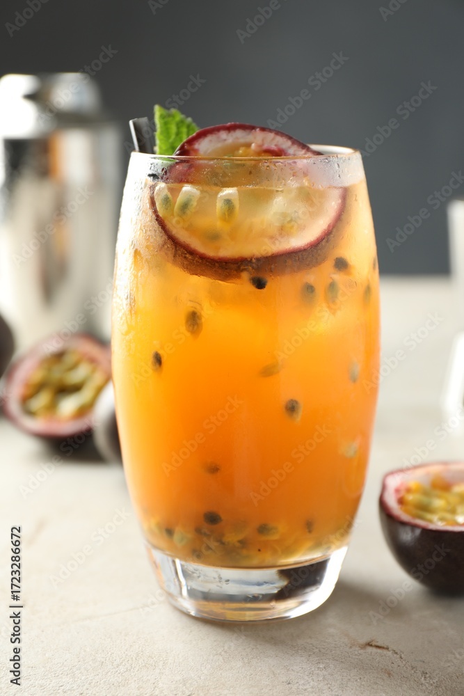 Fototapeta premium Tasty passion fruit drink in glass on gray table, closeup