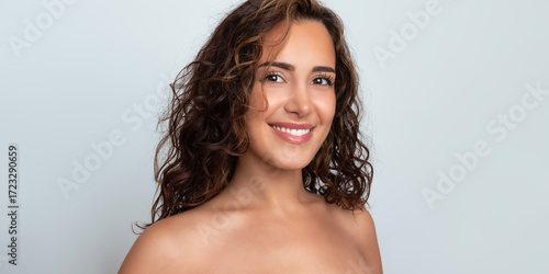 Beautiful young woman with glowing clear skin after skincare and pretty smile 