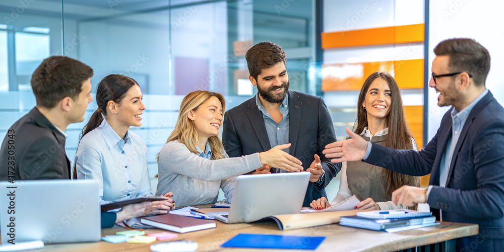 Obraz premium Business team leader woman is welcoming new team member with handshake while colleagues are excitedly watching during office meeting