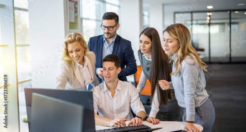 Konstfotografi Business people gathered around young colleague at computer discussing potential
