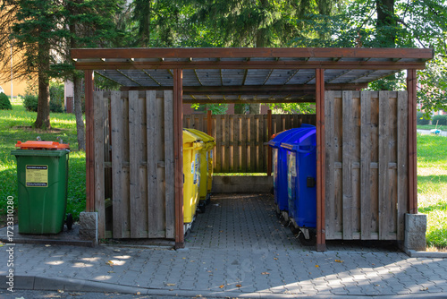 Shed with separate recycling containers for paper and plastic outdoors