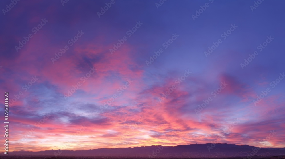 Fototapeta premium Stunning sunset or sunrise sky with vibrant hues of deep blue, pink, purple,