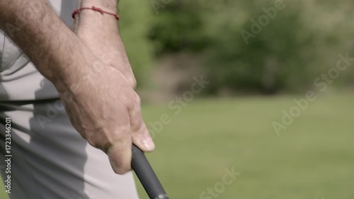 Golfer’s hand gripping club in detail