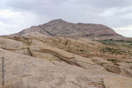 The picture shows a stone mountain with remarkable relief and the nature surrounding it