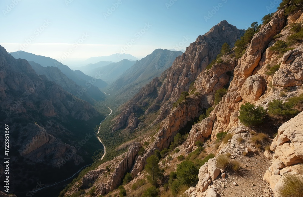 Naklejka premium Mountain landscape in southern Spain with winding river. Deep valley with blue waters. Lush plants and rocky terrain. Aerial view from high vantage point. Comprehensive view of valley and river.