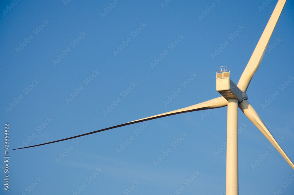 Fototapeta premium Renewable energy. Wind power plant in autumn field during sunrise.Building wind turbines. Wind turbine base.
