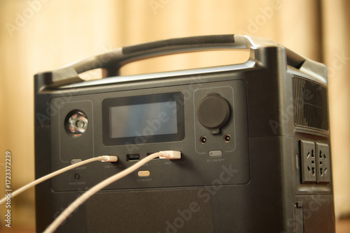 Portable power station charging a phone close-up. Backup energy