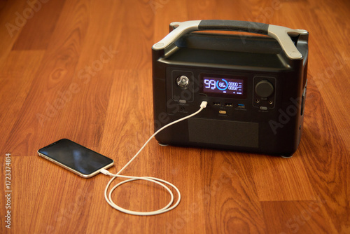 Portable power station charging a phone. Backup energy