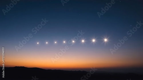 Six bright points of light aligned in the twilight sky above a dark, silhouetted horizon.