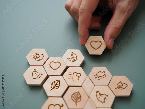 Hand placing a wooden hexagon tile with a heart symbol onto a board