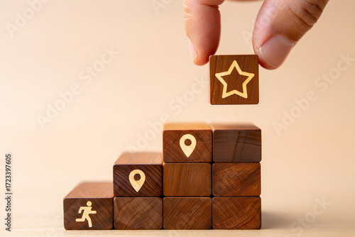 Hand placing star block on top of wooden blocks forming a staircase