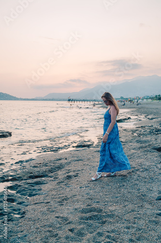 Woman sits on the beach and...