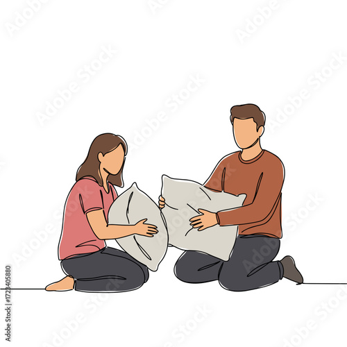 Young couple playfully having a pillow fight on the floor  