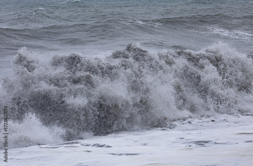Obraz premium A large wave is crashing on the shore