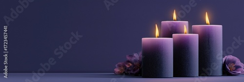 Banner with softly glowing purple candles decorated with flowers on purple background, symbolizing the beginning of Advent