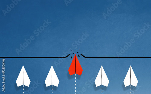 Red paper plane breaking through obstacle on blue background, Concept of overcoming barriers, goal, target