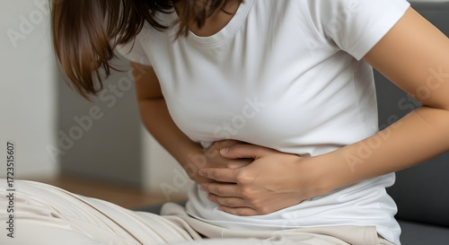 Woman experiencing stomach pain discomfort ache cramps holding abdomen feeling unwell health issue medical problem healthcare symptom illness