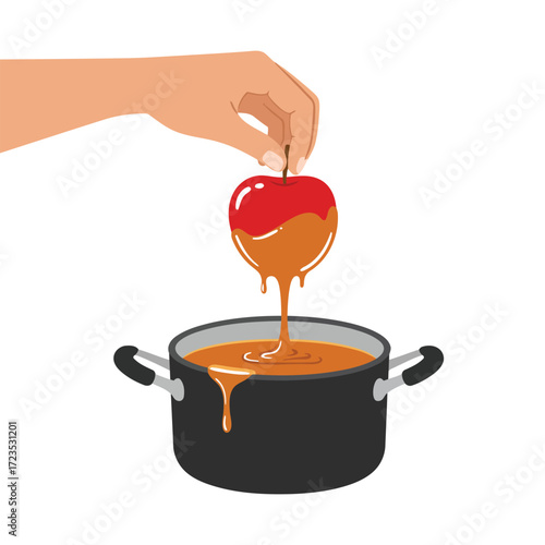 A hand dips a red apple on a stick into a pot of melted caramel, creating a delicious caramel apple.