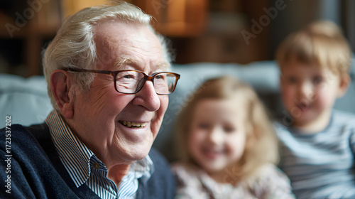 An elderly man laughs with his grandchildren