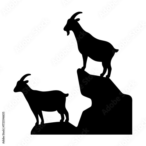 Two goats standing on rocky outcrops silhouette