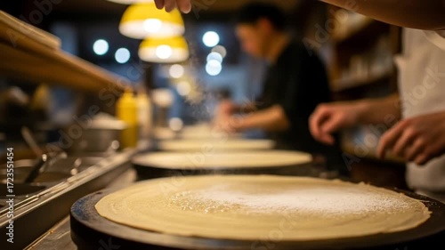 Chefs preparing delicate crepes in a bustling restaurant kitchen with a warm, inviting atmosphere