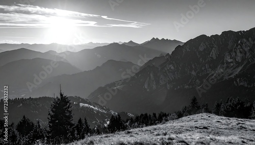 B&W photograph depicts a mountain range with varying levels of sharpness and detail, bathed in morning sun