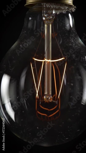 Vintage light bulb glowing with filament in dark background  