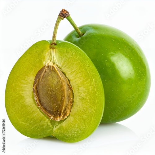 Vibrant green plums, one halved, showcasing its texture and internal pit on white