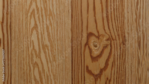 This image shows a close-up view of a wooden surface with a smooth, polished finish. The wood grain is visible, running vertically with a light tan or beige color and subtle texture.