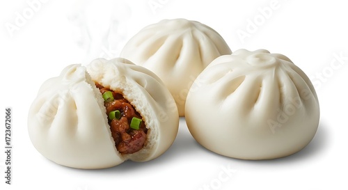 Three steamed bao buns, one of which is cut open to reveal a savory filling of meat and green onions.
