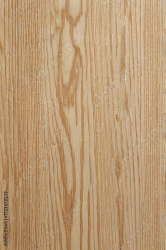 This image shows a natural wooden surface with a distinct and bold grain pattern. The wood has a warm beige tone with dark brown lines forming wavy, organic shapes along the length.