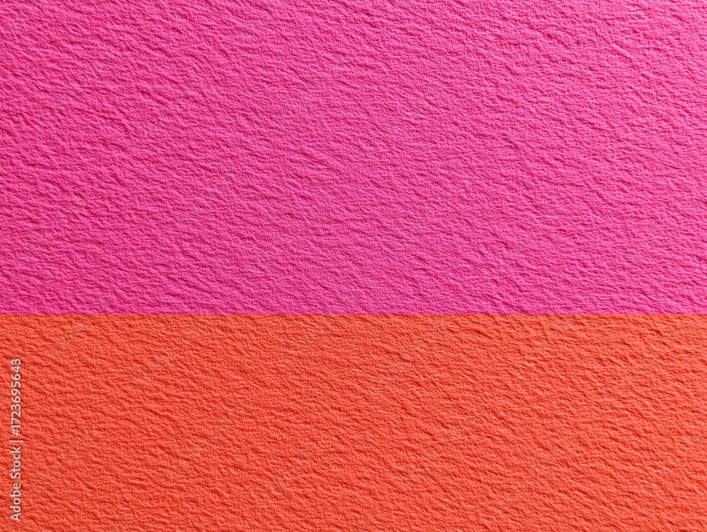 Fototapeta premium Brightly colored textured background of vibrant pink and orange hues, divided horizontally for visual contrast.