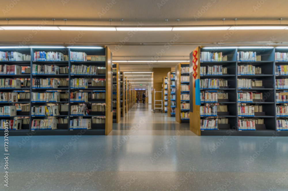 Obraz premium Blurred background of quiet library bookshelves and aisles.