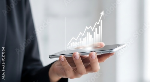 Woman holds phone showing upward growth chart