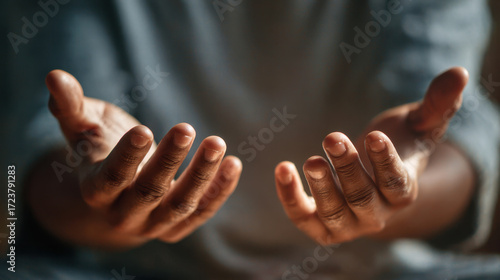 Outstretched hands reaching forward with fingers slightly curved together in soft focus light representing openness and vulnerability as a gesture of welcome or invitation.