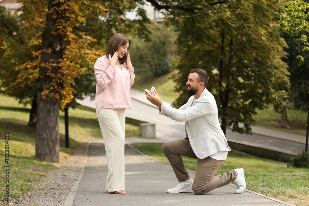 Fototapeta premium Man with engagement ring making marriage proposal to his girlfriend outdoors