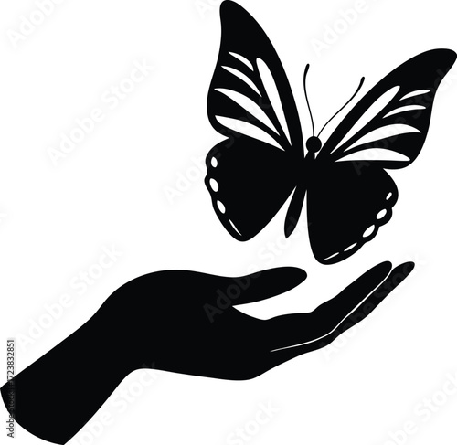Delicate silhouette of a hand gently holding a butterfly