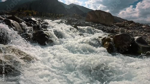 Bright sunlight plays on the surface of the water in a mountain river