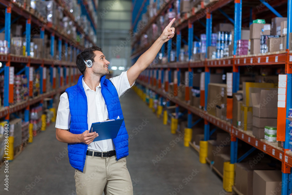 Naklejka premium Blue clipboard resting on metal shelving rack in warehouse with cardboard boxes and yellow bollards