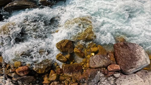 Swift water crashing against rocks in a riverbed