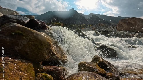 A turbulent flow of water making its way through a stony riverbed