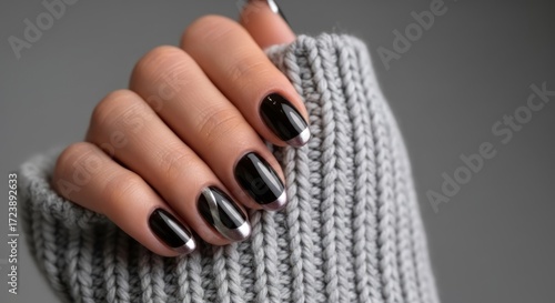 Wallpaper Mural Elegant hand with chic black and silver French tip manicure on cozy grey sweater background Torontodigital.ca