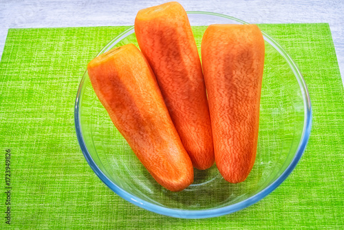 Washed and peeled carrots in a transparent plate.